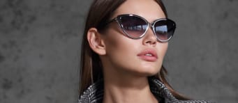 Woman wearing sunglasses against gray background